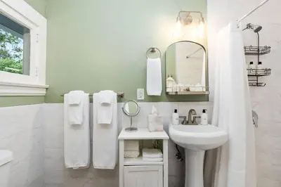 a white bathroom with a sink and a mirror at Grape Escape Inn & Suites in Lodi