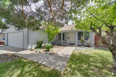 a white house with a tree in the yard at Centrally Located Reno Retreat with Patio and Yard in Reno
