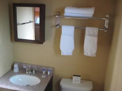 a bathroom with a sink and a mirror and a toilet at Americas Best Value Inn - Porterville in Porterville