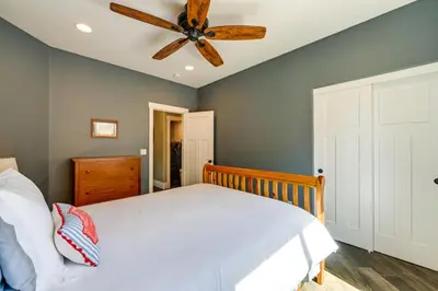 a bedroom with a white bed and a ceiling fan at California Vacation Rental with Private Pool and Patio in Visalia
