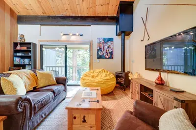 a living room with a couch and a flat screen tv at Cozy Kings Beach Condo Near Lake Tahoe and Skiing in Kings Beach