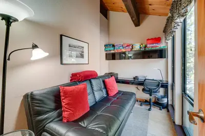 a living room with a leather couch and a desk at Cozy Kings Beach Condo Near Lake Tahoe and Skiing in Kings Beach