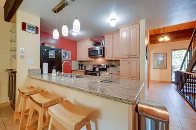 a kitchen with a counter and some wooden stools at Cozy Kings Beach Condo Near Lake Tahoe and Skiing in Kings Beach