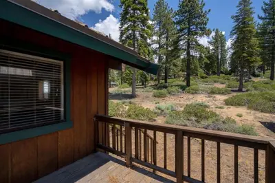 a balcony of a cabin with a view of a yard at Cozy 3BDR - 1 Minute to the Beach! in Tahoe Vista