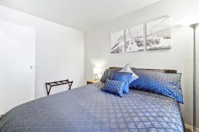 a bedroom with a blue bed with blue pillows at 10 Mi to Palisades Tahoe! Condo with Game Room in Tahoe City