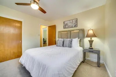 a bedroom with a large white bed and a lamp at Relax Fireside! Tahoe Area Home 28 Mi to Slopes in Carson City