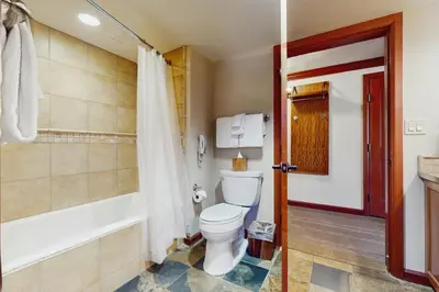 a bathroom with a toilet and a bath tub at Resort at Everline Resort & Spa #560 in Olympic Valley