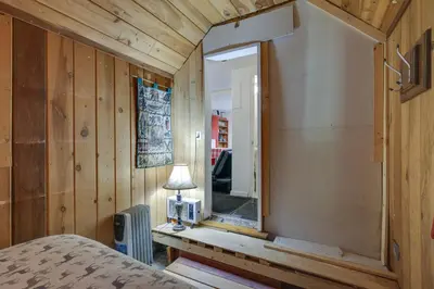 a bedroom with a window in a wooden wall at Dodge Ridge Pinecrest Mountain Cabin Near Hiking! in Cold Springs