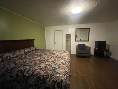 a bedroom with a bed and a chair in it at Oak Motel Modesto CA in Modesto