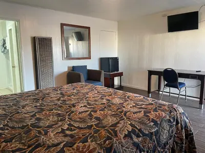 a hotel room with a bed and a desk at Oak Motel Modesto CA in Modesto