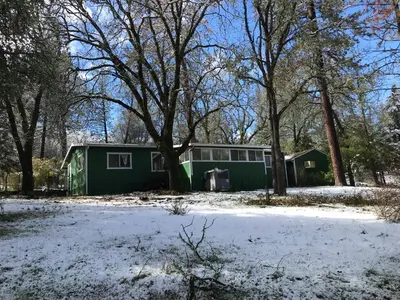 a green house with snow on the ground at Green Cabin in Midpines in Midpines