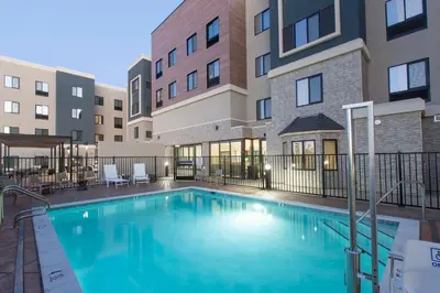 a swimming pool in front of a apartment building at Staybridge Suites Manteca by IHG in Manteca