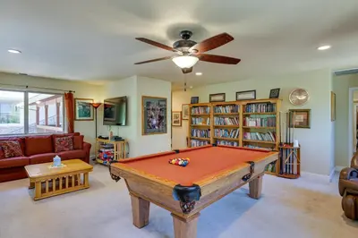 a pool table in a living room with a ceiling fan at Groveland Vacation Rental Near Pine Mountain Lake! in Groveland