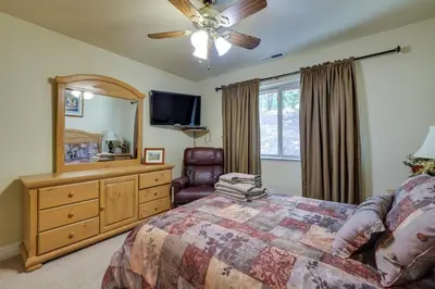 a bedroom with a bed and a dresser and a tv at Groveland Vacation Rental Near Pine Mountain Lake! in Groveland