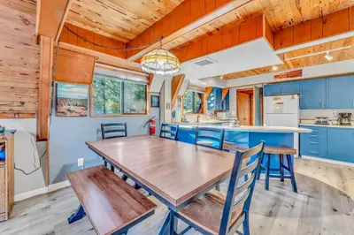 a dining room and kitchen with a wooden table and chairs at 3BR Tahoe Cabin in the Trees with Hot Tub in Carnelian Bay