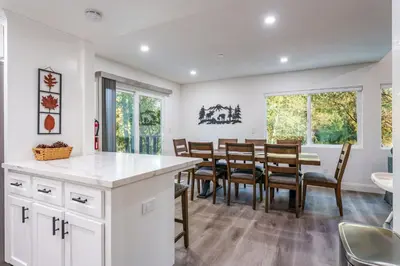 a kitchen and dining room with a table and chairs at A Modern Hideaway - with hot tub, game room, and more in Oakhurst