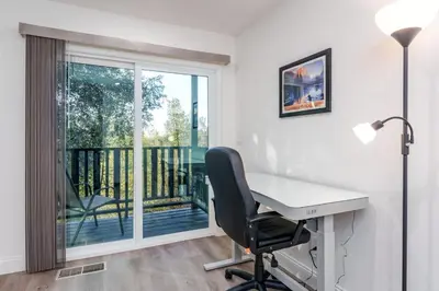 a desk and a chair in a room with a balcony at A Modern Hideaway - with hot tub, game room, and more in Oakhurst