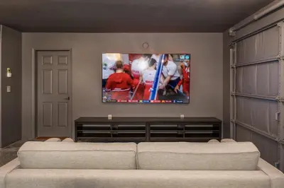 a living room with a couch and a flat screen tv at Yosemite Sunrise House with hot tub/views/game room in Oakhurst