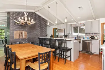 a kitchen and dining room with a wooden table and chairs at Sierra Mountain Escape - Brand new spa/game room in Oakhurst