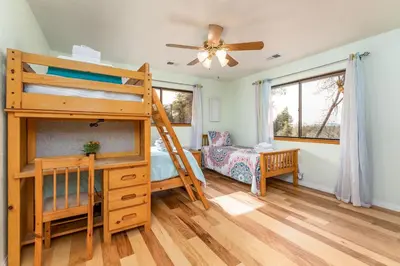 a bedroom with a bunk bed and a desk at Sunset Retreat- TWO houses with hot tub, firepit, multiple kitchens, sleeps 20 in Coarsegold