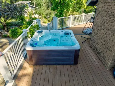 a hot tub sitting on top of a deck at Yosemite Creekside Retreat with spa/games/EV Charger and more in Oakhurst