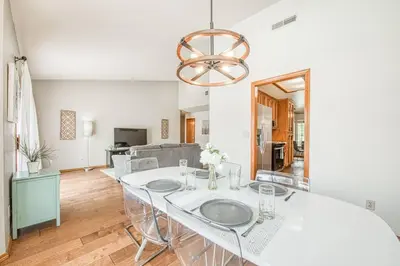 a dining room with a white table and a chandelier at Stylish 3BR/2BA Retreat w/ Pool! Dream Getaway in Fresno