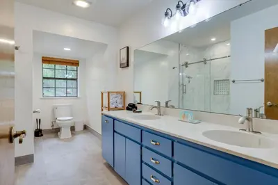 a bathroom with two sinks and a mirror and a toilet at Mi-Wuk Village Vacation Rental with Multi-Level Deck in Mi-Wuk Village