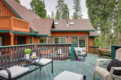 a deck with chairs and tables on a house at Mi-Wuk Village Vacation Rental with Multi-Level Deck in Mi-Wuk Village