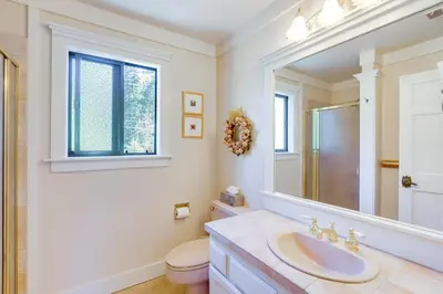a bathroom with a sink and a toilet and a mirror at 2 Mi to Lake Tahoe Spacious and Serene Retreat! in Tahoe City