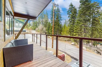 a balcony with a chair and a view of the woods at Red Mountain Lodge in Truckee