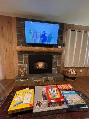 a living room with a fireplace and books on a table at Cozy Ski Condo - Walk to Canyon - Dog Friendly in Mammoth Lakes