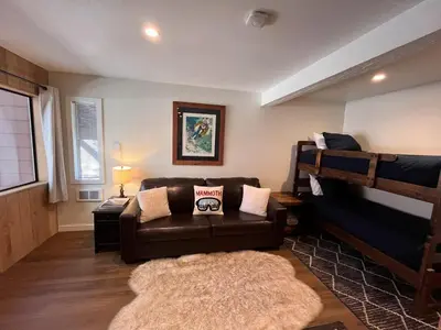 a living room with a couch and bunk beds at Cozy Ski Condo - Walk to Canyon - Dog Friendly in Mammoth Lakes