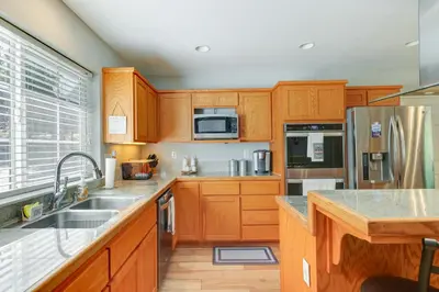 a kitchen with wooden cabinets and stainless steel appliances at Near Dtwn Twain Harte Home with Furnished Deck! in Twain Harte