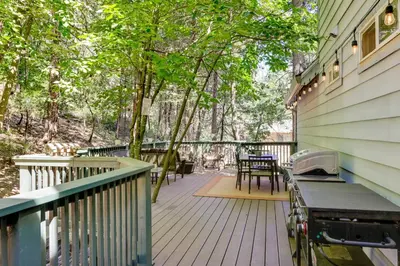 a deck with a table and chairs on a house at Near Dtwn Twain Harte Home with Furnished Deck! in Twain Harte
