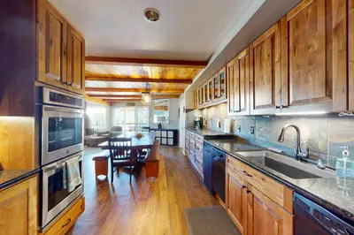 a kitchen with wooden cabinets and a table in it at Bass Lake Lodge in Bass Lake