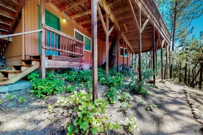 a house with a porch and stairs on it at Bass Lake Lodge in Bass Lake