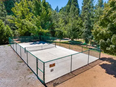 a tennis court with a net on top of it at Deck and Gas Grill Secluded Arnold Cabin Rental! in Arnold