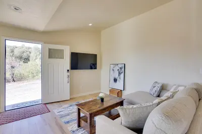 a living room with a couch and a table at Comfy Oakhurst Duplex Near Hiking and Sightseeing! in Oakhurst