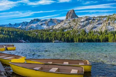 three boats on the shore of a lake with mountains at Crestview 70 in Mammoth Lakes