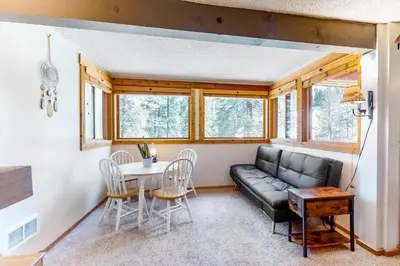 a living room with a black leather couch and a table at Master Units 18A & B at Granlibakken in Tahoe City
