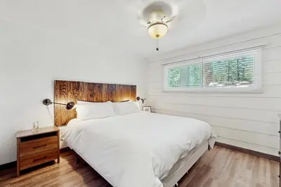 a white bedroom with a large bed and a window at Manzanita Holiday in South Lake Tahoe