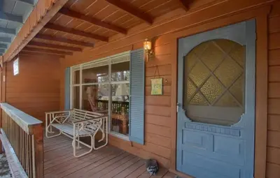 a porch of a house with a door and a chair at Robins Nest- Lake Area Free Night Special in Bass Lake
