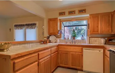 a kitchen with wooden cabinets and a window at Robins Nest- Lake Area Free Night Special in Bass Lake