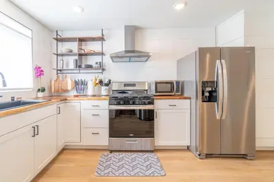 a kitchen with stainless steel appliances and white cabinets at Urban Haven in Reno: Charming Studio Retreat in Reno