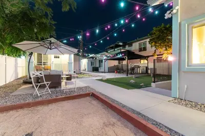 a patio with an umbrella and chairs and lights at Urban Haven in Reno: Charming Studio Retreat in Reno