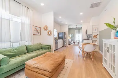 a living room with a green couch and a table at Reno Dream Cottage: Delightful 2-Bedroom Sanctuary in Reno