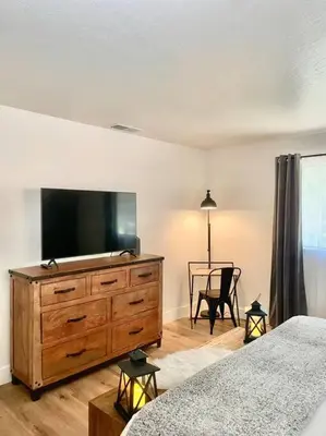 a bedroom with a large dresser with a flat screen tv at FirePit~Horseshoes~King Bed~Near Lake, Wine, Farms in Pollock Pines