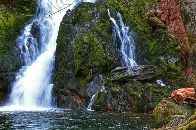a waterfall on the side of a rocky mountain at FirePit~Horseshoes~King Bed~Near Lake, Wine, Farms in Pollock Pines