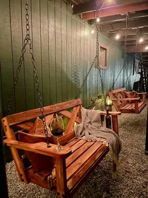 a swing with a glass of wine sitting on it at FirePit~Horseshoes~King Bed~Near Lake, Wine, Farms in Pollock Pines