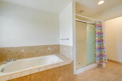 a bathroom with a tub and a glass shower at Porterville Getaway with Patio and Valley Views! in Porterville